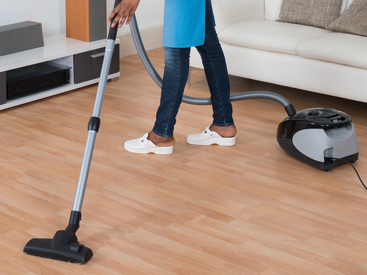 Image of a woman vacuuming a hardwood floor