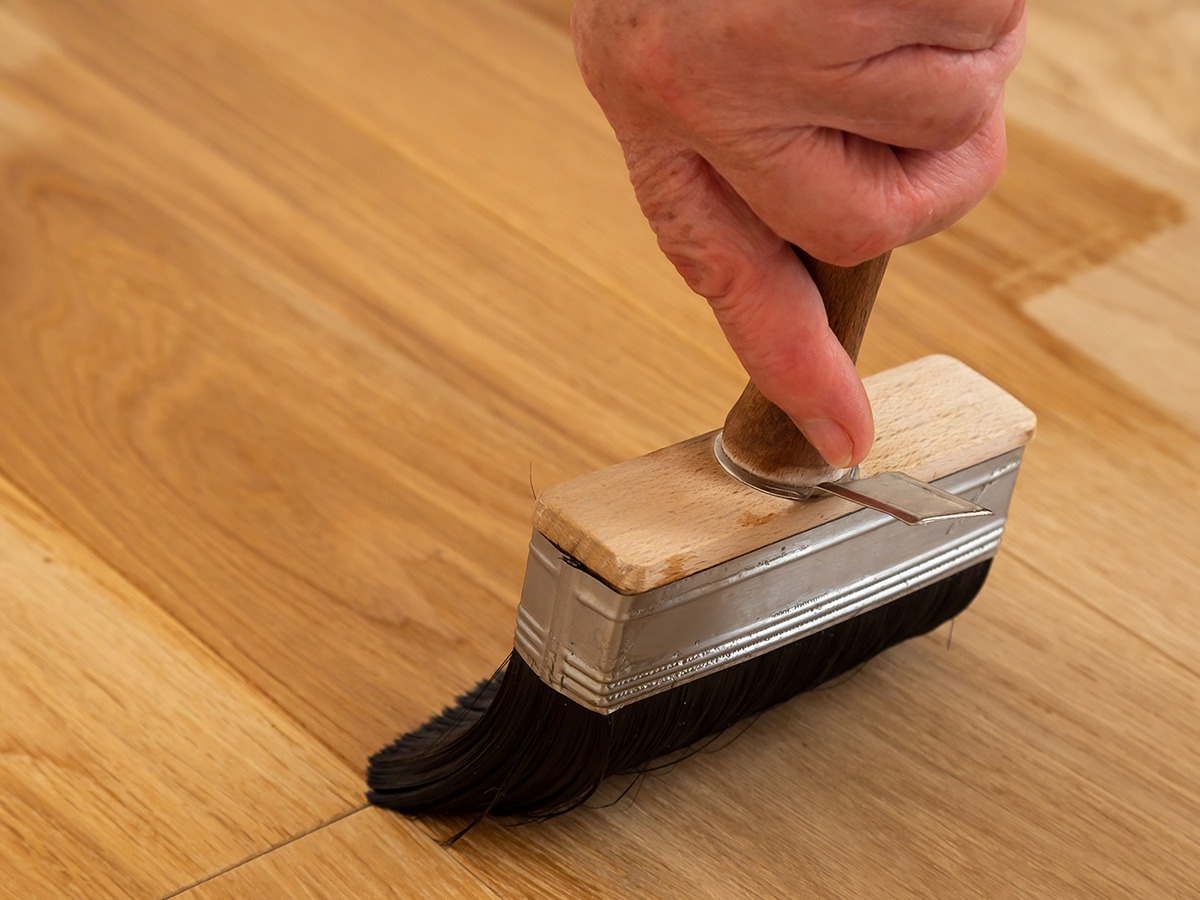 Image of a person using finish on a hardwood floor